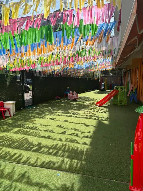 Kaydırak ve tahterevalli bulunan süslü bahçe